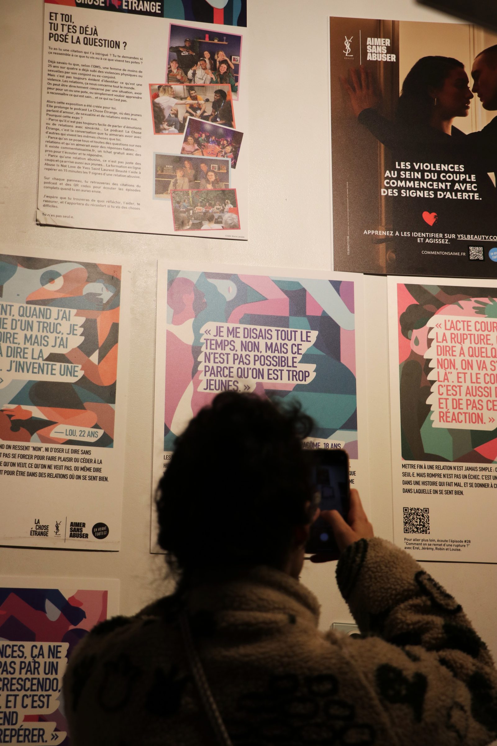 Une visiteuse scanne le QR code d'un panneau avec son téléphone